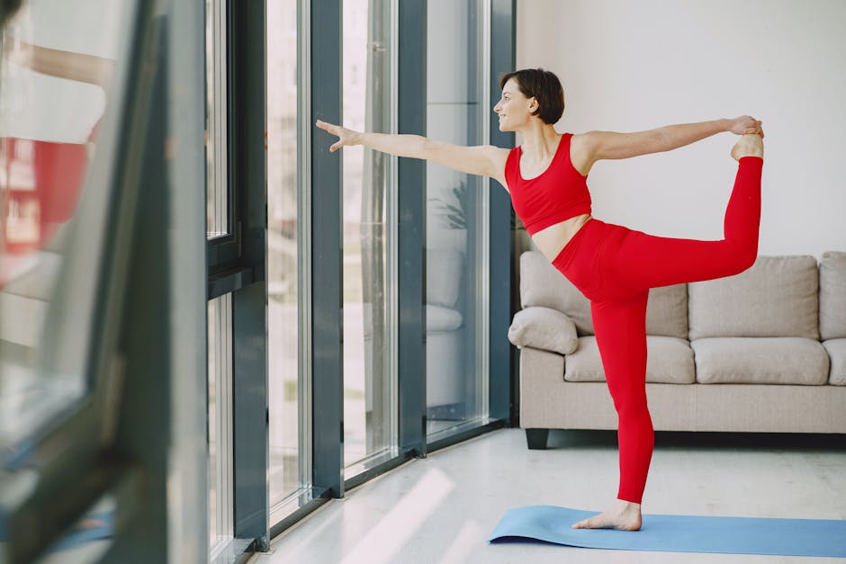 Serene pregnant woman doing a gentle side stretch yoga pose at home.